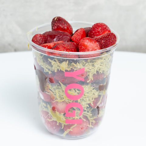 Clear plastic cup filled with strawberries and a colorful design on a white background